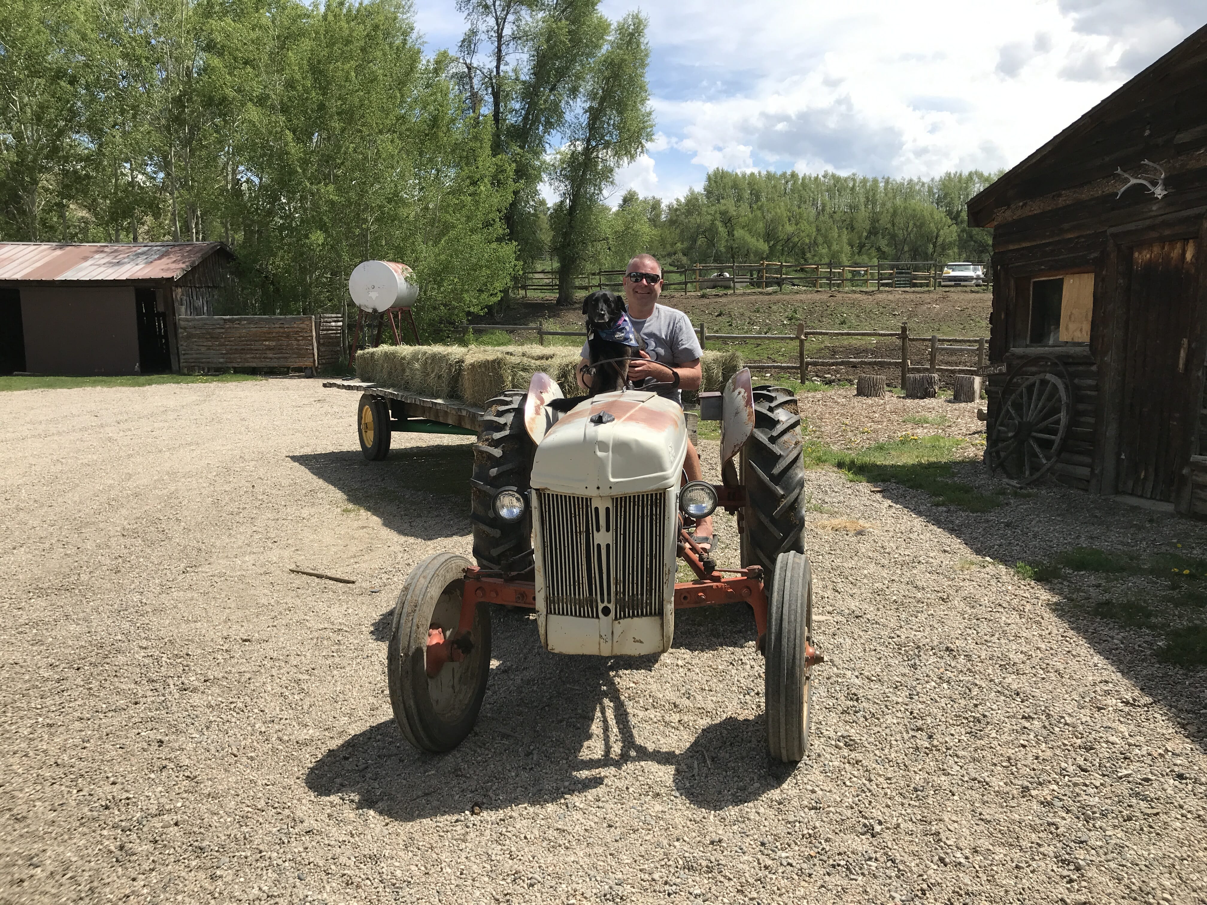 Adam and his dog, Holland, sitting on a tractor at the ranch